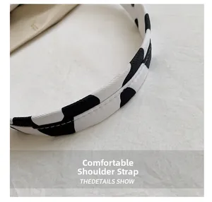 Detail of soft shoulder strap with black and white cow print and fine white stitching