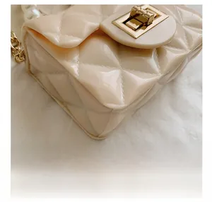 Detailed macro view of cream jelly handbag with diamond quilt pattern and pearl handle