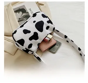 Detail showing the inner capacity of a cow print baguette bag with phone and wallet
