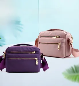 Waterproof nylon crossbody bags in purple and pink with gold zippers and adjustable straps