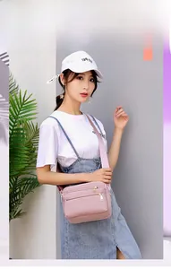 Detail of light pink waterproof nylon crossbody bag with adjustable wide shoulder strap