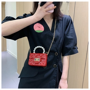 Detailed view of red mini quilted jelly bag with large pearl handle and gold chain strap