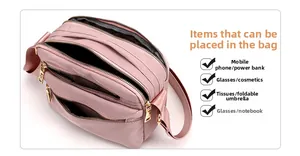 Detail view of pink nylon crossbody bag showing multiple organized zipper compartments