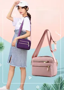 Detail of water-resistant nylon crossbody bag with multi-layer zippers and adjustable strap