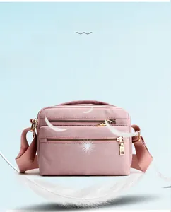 Detail of pink waterproof nylon crossbody bag with three zipper layers and lightweight design