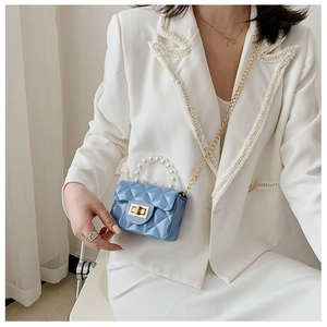Detailed view of sky blue quilted mini crossbody bag with pearl handle and chain