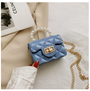 Close-up of sky blue jelly handbag with pearl handle, diamond quilt pattern and gold lock
