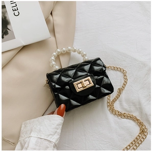 Detail of black quilted mini jelly bag with faux pearl handle and gold chain strap