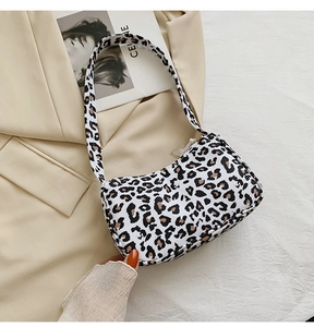 Detail shot of leopard print hobo bag on beige fabric showcasing the trendy texture