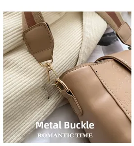 Detail of high-quality golden metal clasp on beige embossed faux leather bucket bag