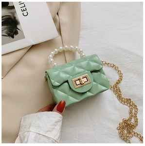 Detail of mint green quilted mini bag with pearl handle and golden chain strap