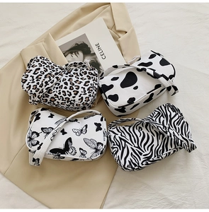 Flat lay of small tote bags in leopard, cow, butterfly, and zebra print patterns