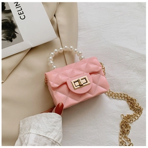 Detail of pink quilted jelly bag with white pearl handle and gold chain strap