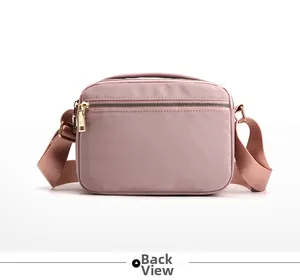 Rear view of pink nylon crossbody bag with zipper pocket and gold-tone hardware detail