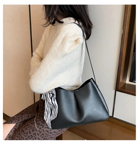 Classic black tote bag with a stylish black and white striped scarf on shoulder