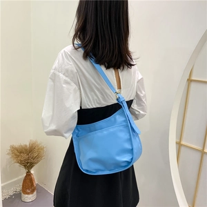 Minimalist sky blue baguette underarm bag with adjustable strap shown on model back