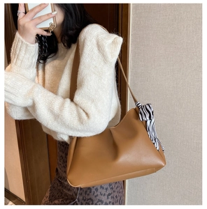 Caramel brown pleated underarm bag with zebra print silk scarf detail shown on shoulder