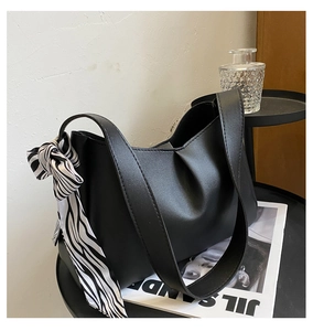 Minimalist black matte shoulder bag with zebra print silk scarf detail and wide strap