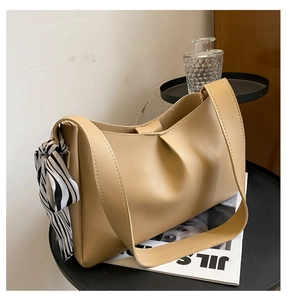 Detail of khaki tote bag with soft leather texture and stylish zebra print scarf