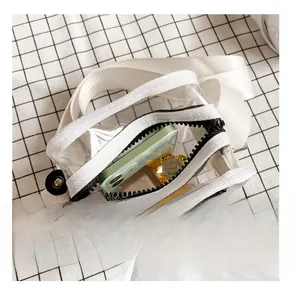 Detail presentation showing internal capacity of the clear PVC crossbody bag with white trim