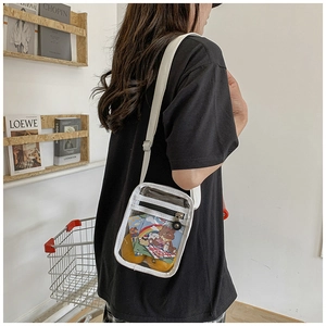 Transparent PVC mini crossbody bag with white trim and fabric strap shown on model