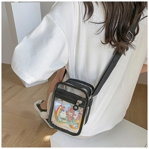 Detail view of mini transparent PVC crossbody bag with black strap worn by a model