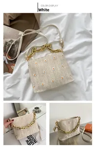 Details der weißen gewebten Gänseblümchen-Tasche mit goldener Kette und Leder-Schultergurt