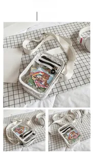 Detail of transparent PVC crossbody bag in white with silver buckle and woven shoulder strap
