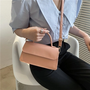 Borsa a tracolla rosa in ecopelle con manico superiore indossata da una modella