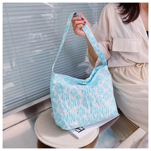 Détail du sac fourre-tout jacquard bleu clair avec motifs de marguerites et fermoir aimanté