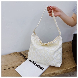Détail du sac hobo blanc ivoire avec texture florale 3D et large bandoulière