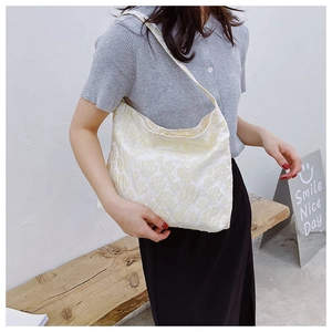 Détail d'un sac à bandoulière en toile crème avec broderie florale 3D de style décontracté