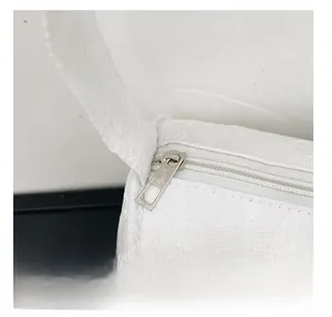 Close-up of white embossed fabric texture and silver metal zipper on the shoulder bag