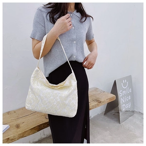 Détails de la texture du sac cabas en jacquard crème avec fleurs 3D et bandoulière
