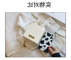 Détails du sac seau crème avec bandoulière chaîne dorée et picots de protection