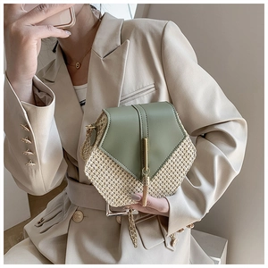 Close-up of woven texture and dark green leather flap with gold metal hardware