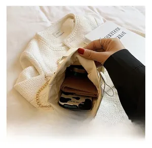 Détail montrant la capacité intérieure de la pochette nuage plissée crème avec objets