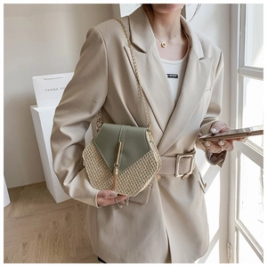 Chic woven beige and green leather honeycomb crossbody bag worn with gold chain strap