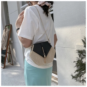 Chic straw woven crossbody bag with black leather flap and gold tassel detail