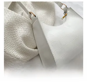 Close-up of white crocodile pattern patent leather shoulder bag with golden buckle hardware