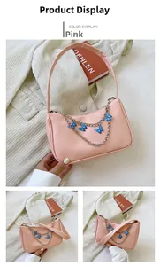 Detailed view of a pink baguette shoulder bag with decorative silver butterfly chain charms