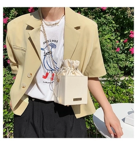 Détail du sac seau cube blanc crème avec cordon de serrage et bandoulière chaîne