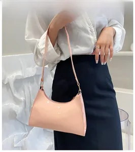 Pink crocodile-embossed faux leather baguette bag worn by a model in a minimalist setting