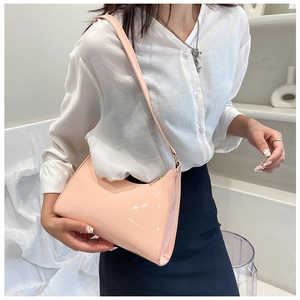 Pink faux crocodile leather shoulder bag styled on model with white shirt and skirt