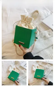 Vue détaillée d'un sac seau carré vert avec matelassage ondulé et chaîne dorée