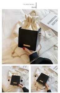 Vue détaillée du sac bandoulière boîte noire avec chaîne dorée et pochette intérieure