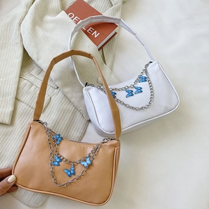 Chic baguette underarm bag with butterfly chain charm in cream and white faux leather