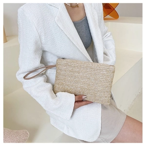 Detail of hand-woven wheat straw clutch with V-shaped texture and wrist strap