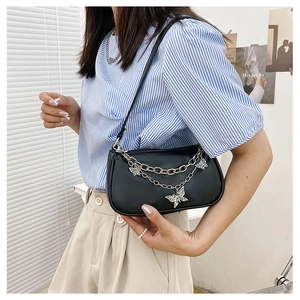 Détail du sac sous le bras en cuir PU noir avec chaînes argentées et pendentifs papillon