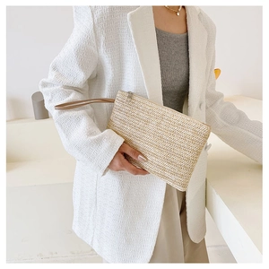 Detail of handmade straw clutch with herringbone weave pattern and wrist strap